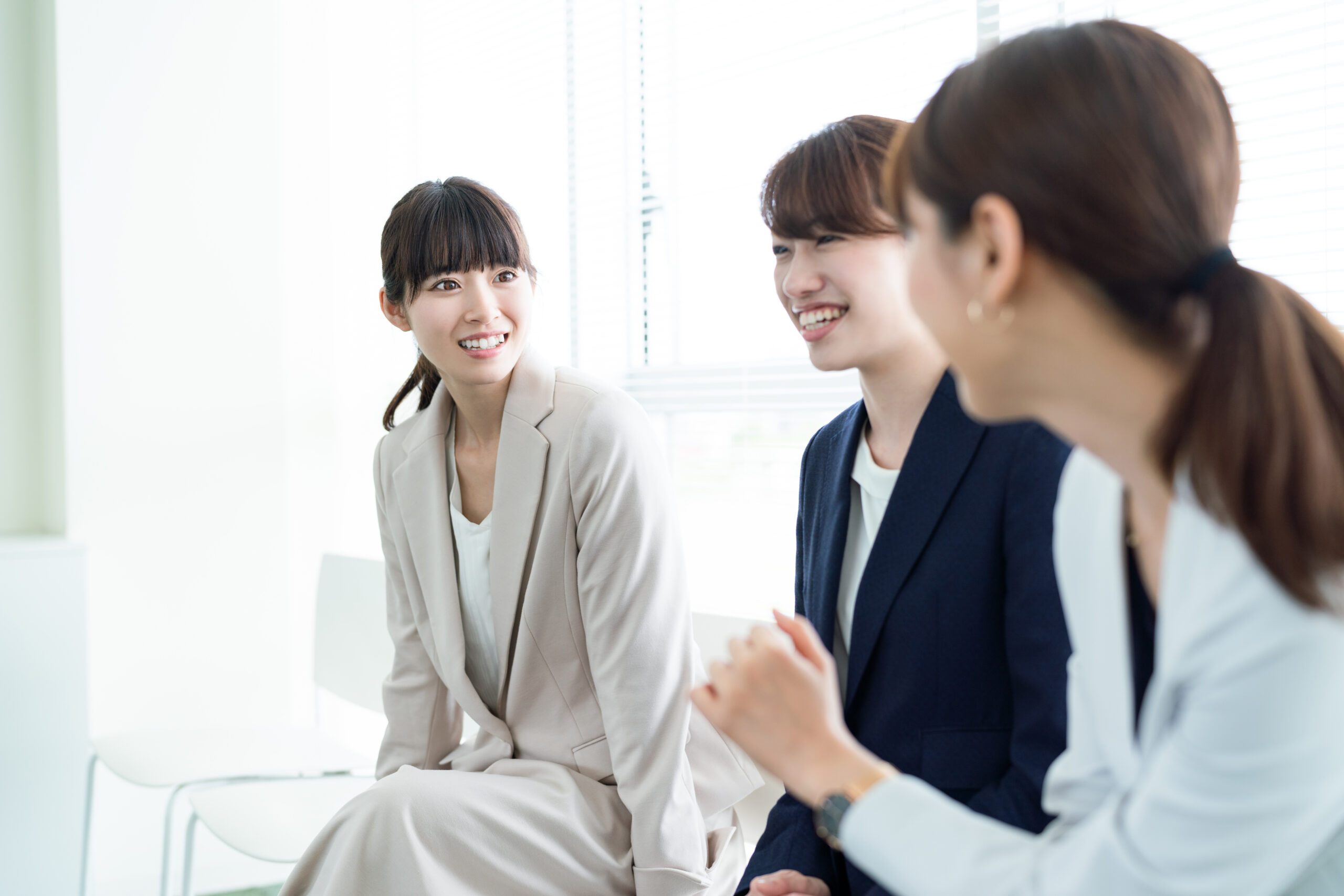 談笑するスーツの女性たち｜社内｜コミュニケーション