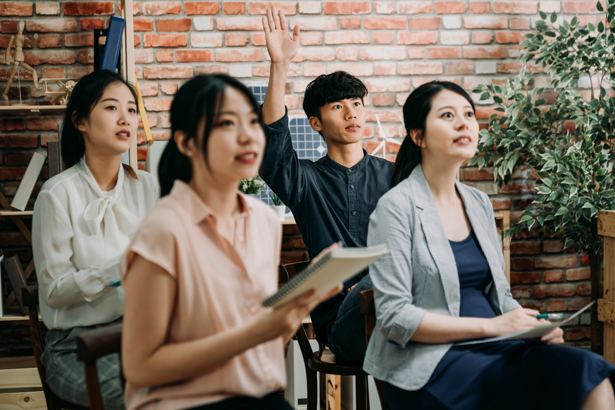 挙手する男性と前方を見つめる女性たち｜企画｜イベント｜社内｜謎解き